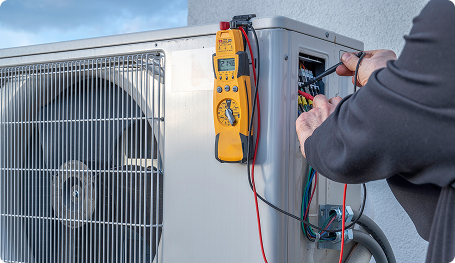 someone using a tool to work on an hvac unit